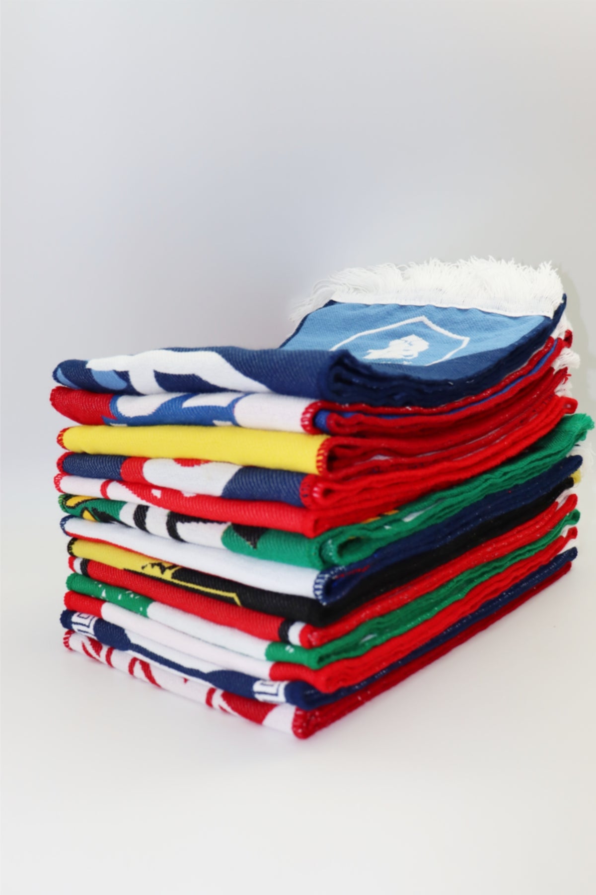 Stack of custom woven scarves in various team colors and design configurations